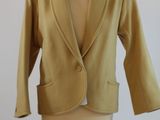 un blazer jaune posé sur un présentoir à mannequin, sur fond blanc