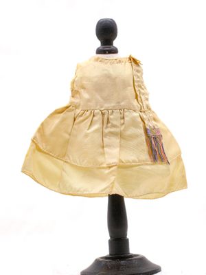 une robe jaune sur un mannequin, sur fond blanc