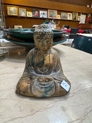 a buddha statue sitting on a table in a room