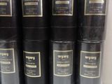 several black and gold cans of perfume sitting on a shelf