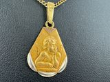 a close up of a necklace with a gold pendant on a black surface