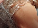 a close up of a doll ' s head with a lot of hair on it