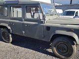 a grey land rover parked in a lot with other cars