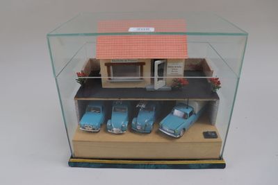 une vitrine contenant trois voitures devant une maison