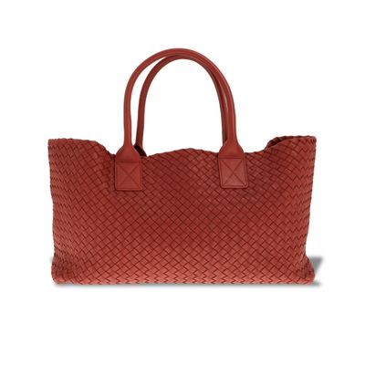 un sac fourre-tout tissé rouge sur fond blanc