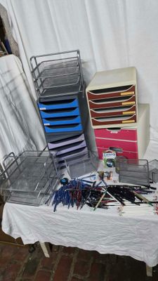 une table sur laquelle se trouvent plusieurs stylos et d'autres objets