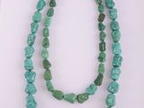 un collier composé de deux rangs de perles turquoise et muni d'un fermoir en argent