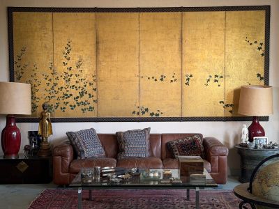 a living room with a couch, table, lamps and a painting on the wall