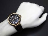 a black and gold wrist watch on a mannequin hand