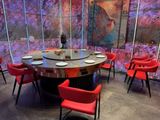 de nombreuses chaises rouges disposées autour d'une table ronde dans un restaurant