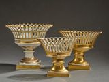 trois vases dorés et blancs posés sur une table