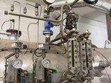pipes and valves in a large industrial building with a clock on the wall