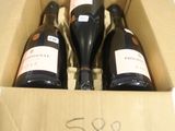 trois bouteilles de vin dans un carton sur une table