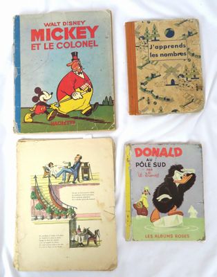 quatre livres pour enfants posés sur un lit recouvert d'un drap blanc