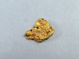 un petit morceau d'or sur une surface blanche