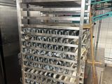 a metal rack that has many trays of food on it