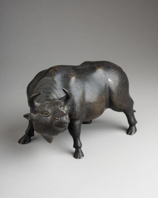 bronze figurine of a bull on a white background