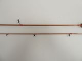 two fishing rods hanging on a wall next to each other