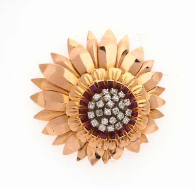 une image représentant une broche en forme de fleur, en or et diamants, sur fond blanc