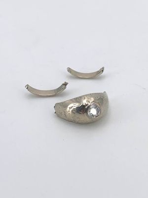 paire de boucles d'oreilles en argent posées sur une surface blanche, sur fond blanc