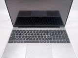 a silver laptop with a black keyboard on a white surface