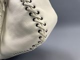 un sac à main blanc avec une anse tressée sur fond gris