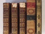 plusieurs vieux livres sont alignés sur une surface blanche