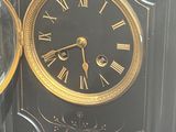 a black clock with gold roman numerals on it