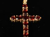 une image représentant une croix en or sertie de grenats sur fond noir