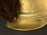 a close up of a gold vase with a broom sticking out of it