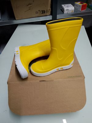 une paire de bottes de pluie jaunes posées sur une boîte en carton