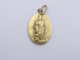 a gold medal with a woman holding a child on it