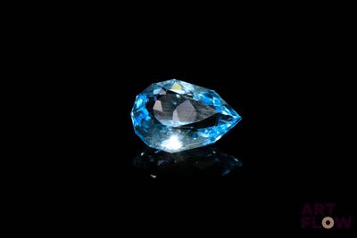 a close up of a blue diamond on a black surface