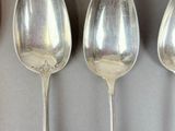 three spoons that are sitting next to each other on a table