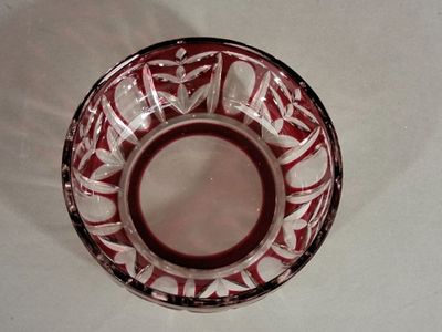 a red and white bowl on a white table