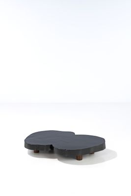 une table basse noire posée sur un sol blanc