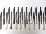 a lot of knives that are lined up on a table