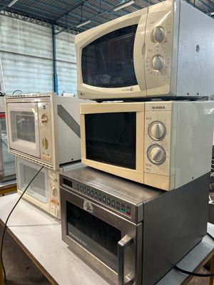 trois micro-ondes empilés les uns sur les autres sur une table