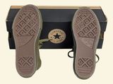pair of brown shoes sitting on top of a box on a white surface