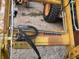 a close up of a yellow tractor with a man standing next to it