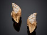 une paire de boucles d'oreilles en or serties de diamants sur fond noir