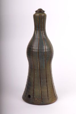 un vase brun posé sur une surface blanche