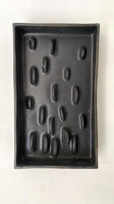 une photo d'un plateau noir sur lequel sont disposés plusieurs clous