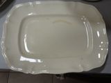 a white platter sitting on top of a table next to a bowl