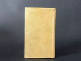 an old book sitting on top of a table next to a black background