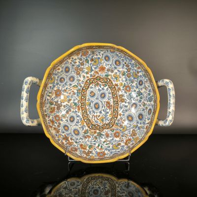 a yellow and blue plate on a stand on a black surface