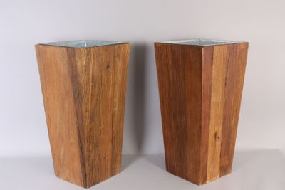 une paire de vases en bois avec des couvercles en verre, posés sur un support blanc