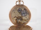 a gold pocket watch on a white surface