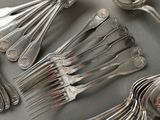 a lot of silver spoons and forks on the table