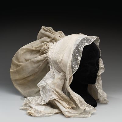un chapeau blanc orné d'un voile, posé sur une tête de mannequin
